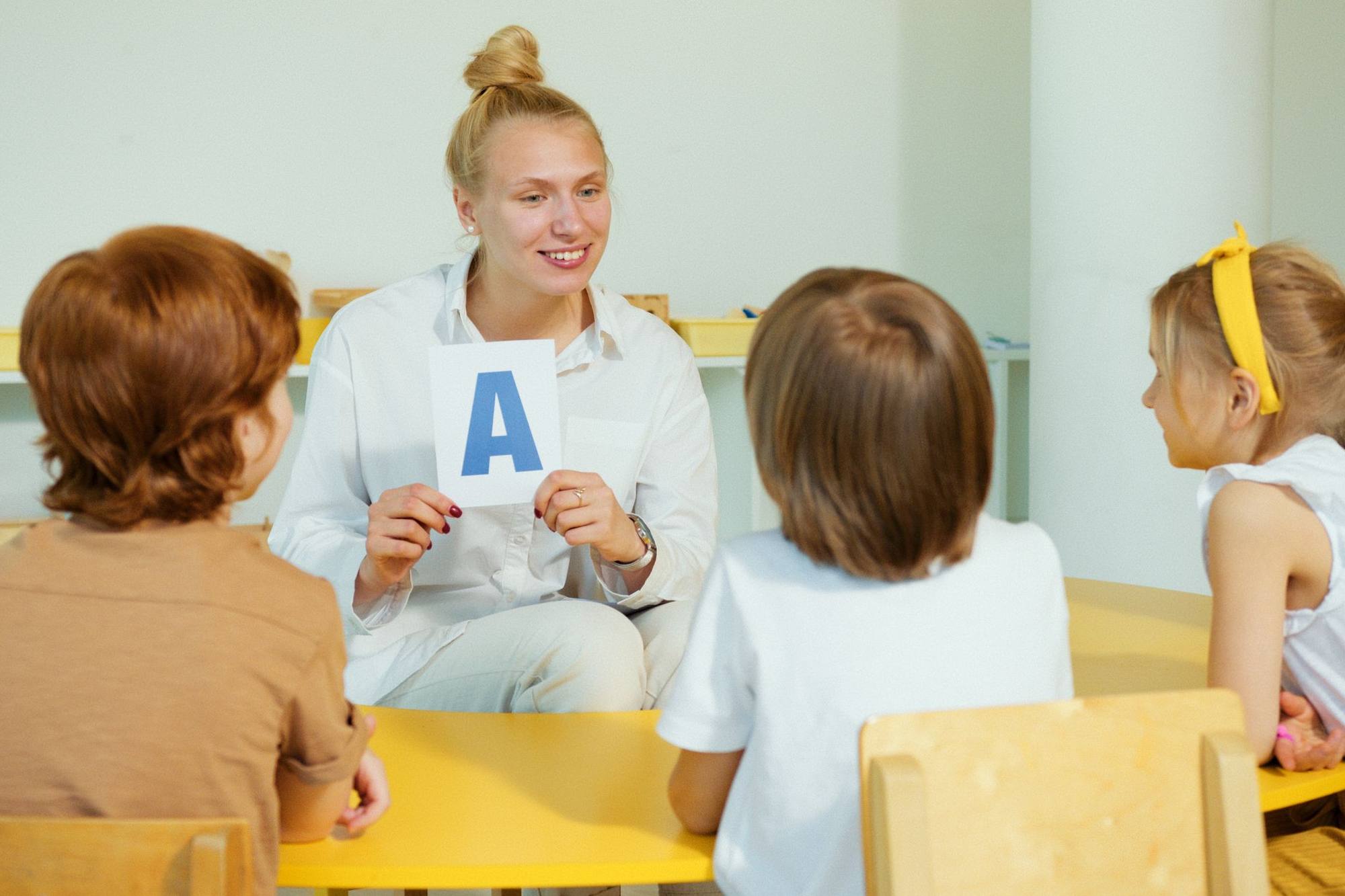 A teacher showing a letter card to a group of young children